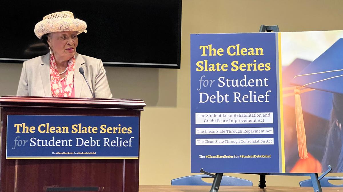 Rep. Adams speaking at a press conference wearing a tan hat.