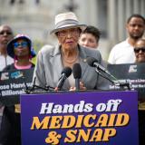 Rep. Adams at a podium for a Hands off Medicaid & SNAP rally