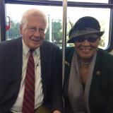 Rep. Alma Adams and Rep. David Price sitting together and smiling on a CATS bus in Charlotte