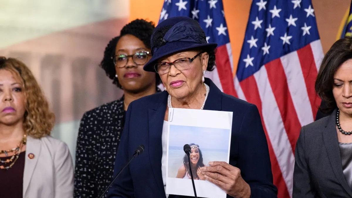 Rep Adams with a photo of Kira Johnson